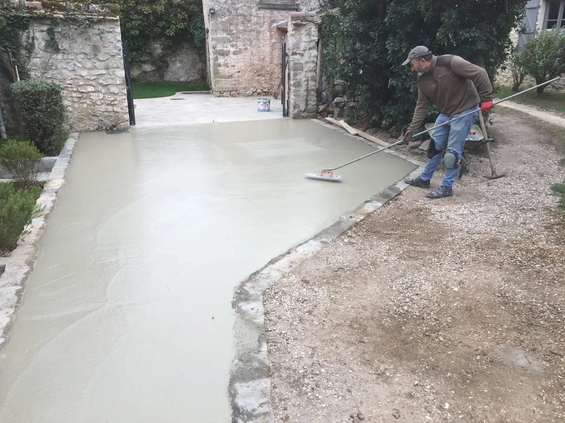 Artisan lissant une allée en béton désactivé